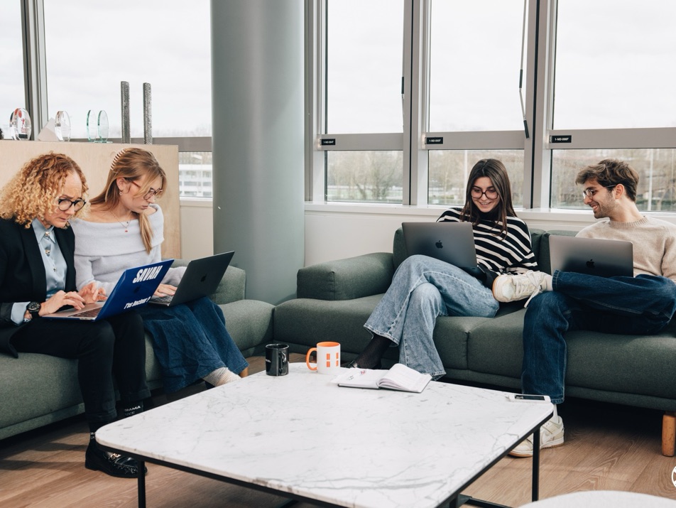 L’équipe au travail sur les canapés de l’agence